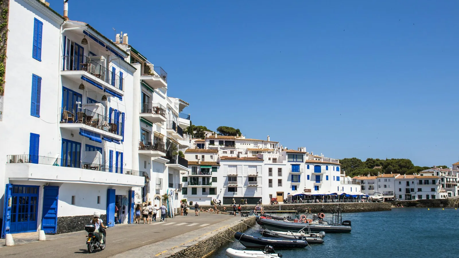 Maisons blanches face à un port méditerranéen sous le soleil de la Costa Brava